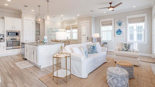 A spacious living area with a white sofa, a coffee table, and a ceiling fan.