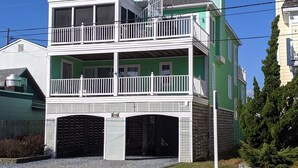 A two-story building with a balcony, a garage, and a clear sky.
