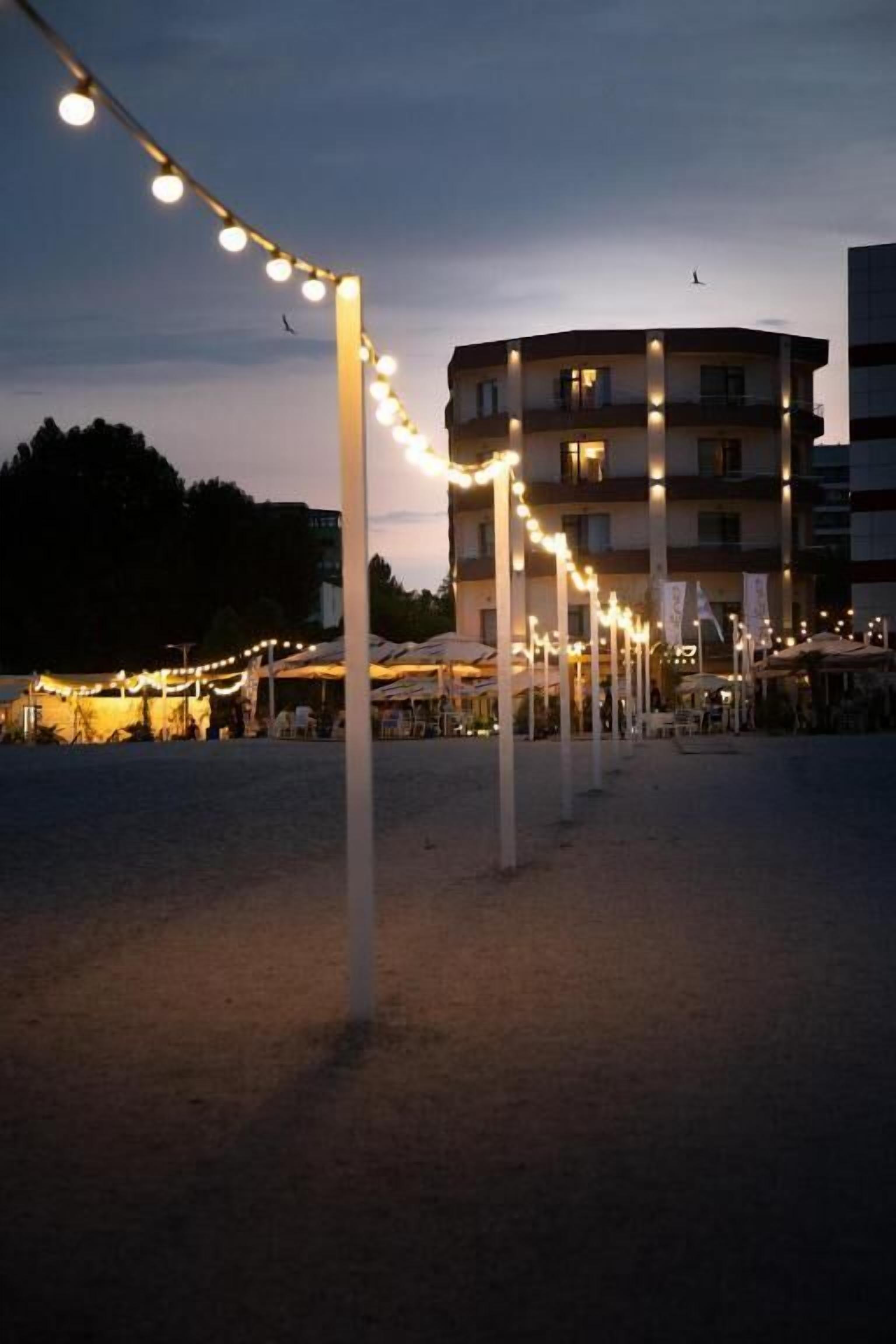 Un immeuble doté de nombreux balcons et d’une rangée de lumières à l’avant.