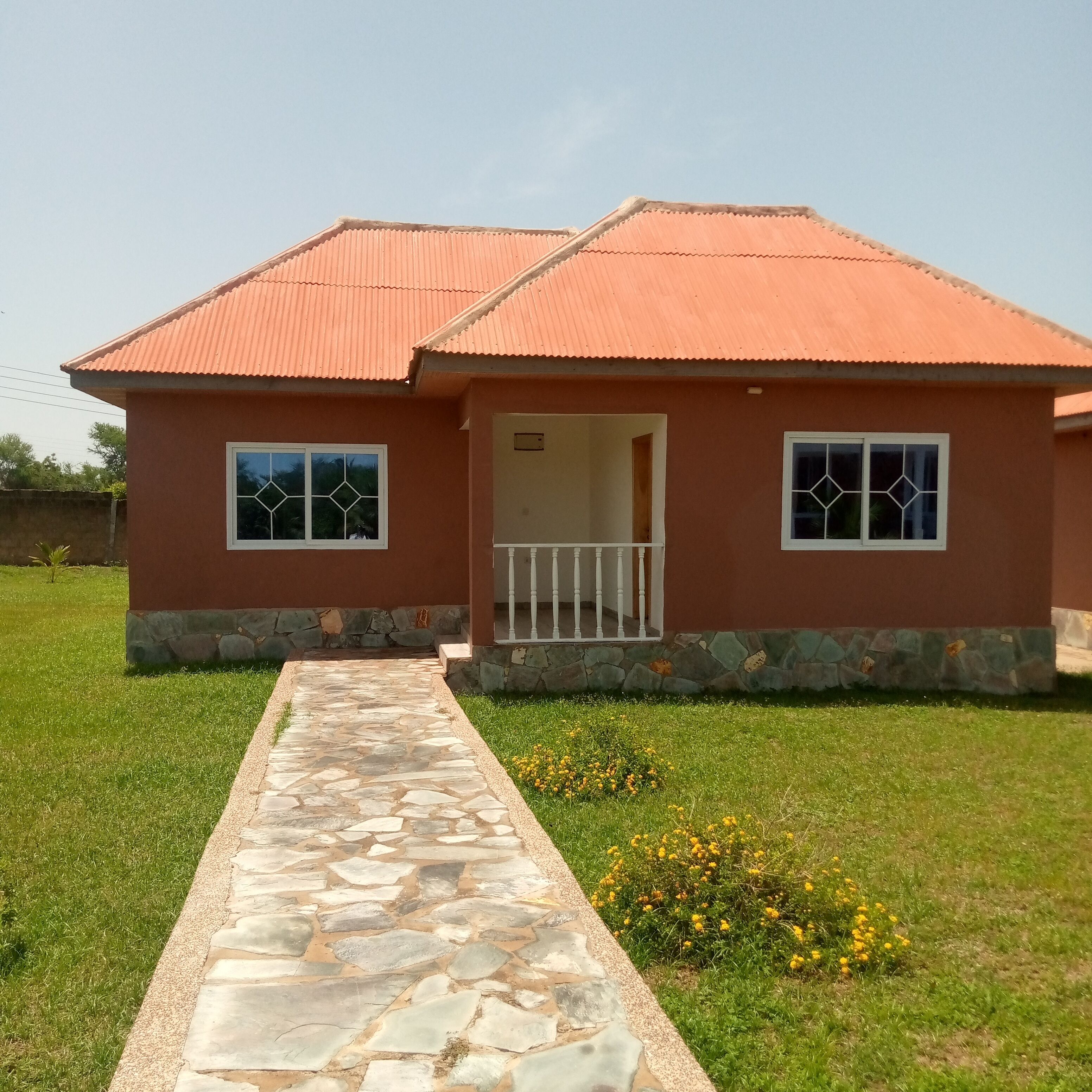Uma casa de dois andares com um caminho de pedra que leva à entrada.