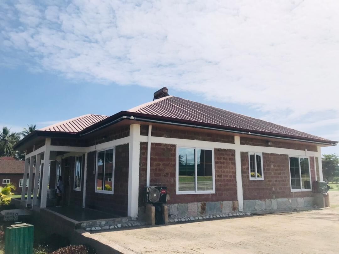 A two-story building with a brick facade and a metal roof.