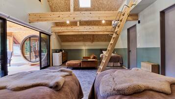 Een gezellige kamer met een hoogslaper, een trapje, een zithoekje en uitzicht op de omgeving.
