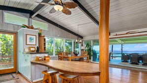 Una cocina amplia con una isla grande de madera, armarios de madera y un ventilador de techo.