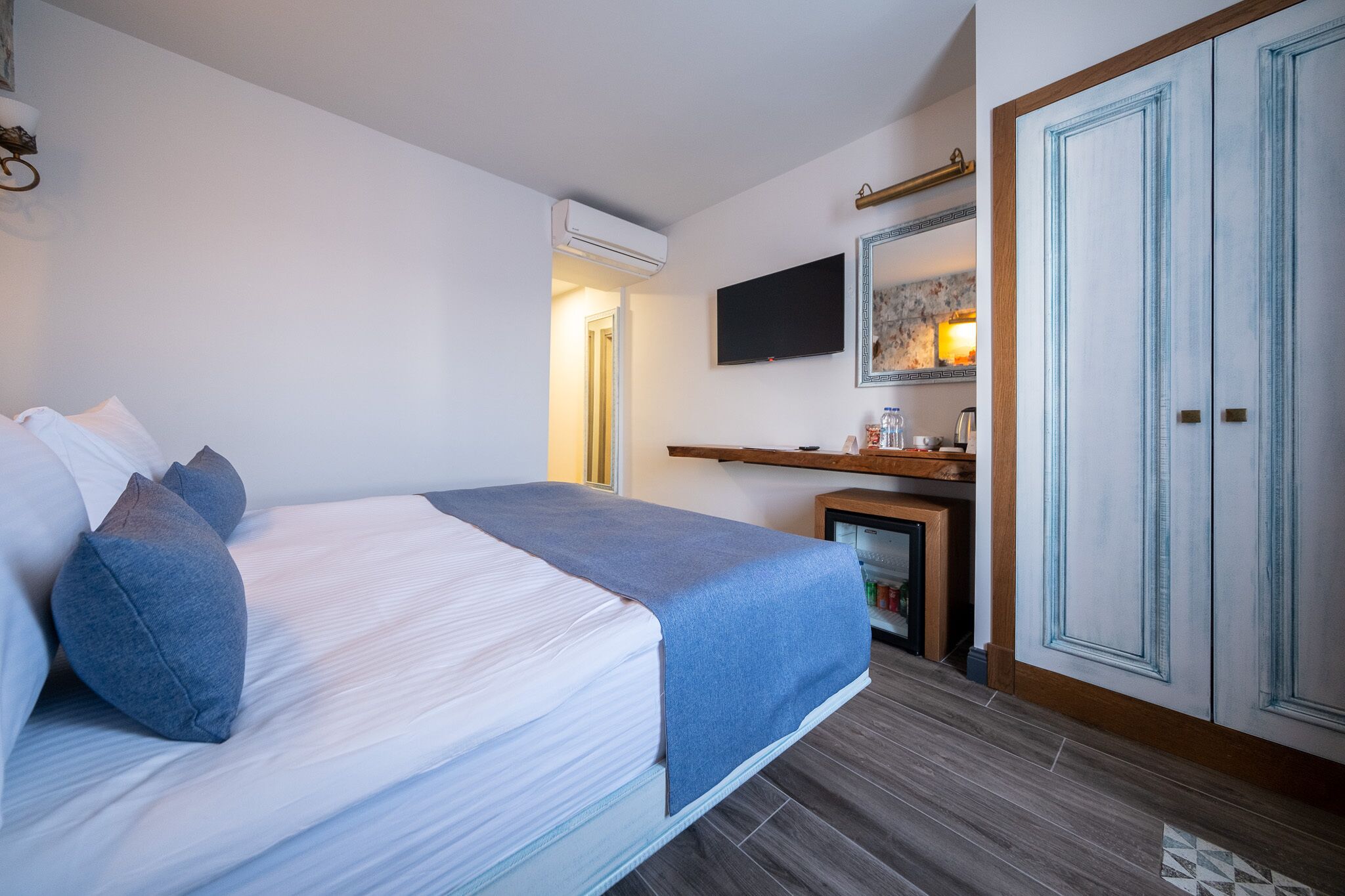 Ein Schlafzimmer mit einem Bett, einem Fernseher, einem Spiegel und einem Kleiderschrank.