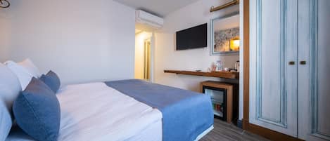 Una camera da letto con un letto, una TV, uno specchio e un armadio.