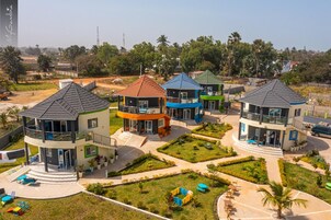 A residential complex with multiple two-story houses, each featuring a balcony and a small garden area.