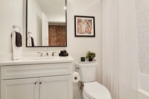 Bathtub, hair dryer, towels, shampoo