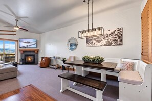 Ein Wohnzimmer mit Kamin, Esstisch und einer Couch.