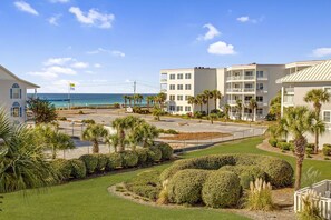 Ein Hotel an der Küste mit Parkplatz, Palmen und Meerblick.