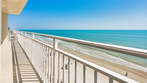Un balcon avec vue sur la plage et l’océan.