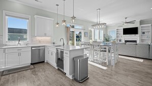A modern kitchen with white cabinetry, stainless steel appliances, and pendant lighting. - The Hamptons #139 Brand new, Oceanfront B,  Hot Tub, Com. Pool! (North Topsail Beach)