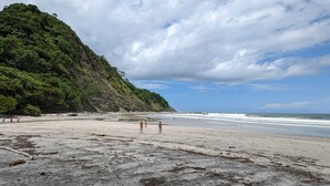 Une plage bordée d’une falaise rocheuse, avec vue sur l’océan.