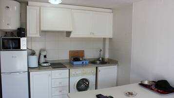 Frigorífico, microondas, cafetera o tetera y utensilios de cocina