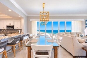 A modern kitchen with white cabinets, a built-in microwave, and a stainless steel sink.