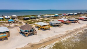 Una zona costera con casas de playa y un muelle que se adentra en el agua.