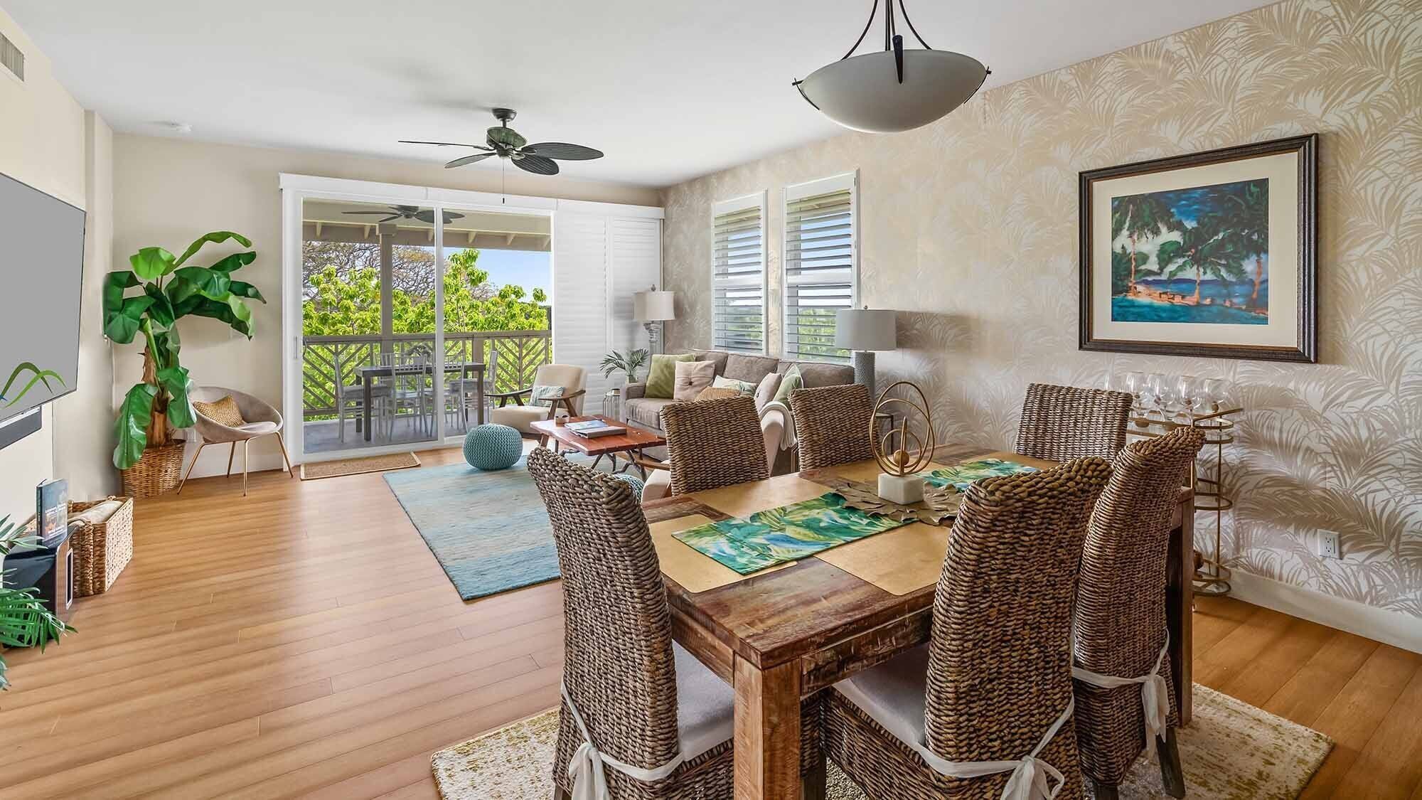 Un comedor amplio con una mesa de madera, sillas de mimbre y vistas a un balcón a través de puertas de cristal.