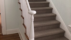 A staircase with white balusters and a wooden handrail, carpeted steps, and a light blue wall. - Bay View Bungalow By The Pier 4 Bedroom Home by RedAwning (Norfolk)