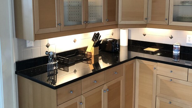 A kitchen with wooden cabinets, black countertops, and a tiled backsplash. - Bay View Bungalow By The Pier 4 Bedroom Home by RedAwning (Norfolk)