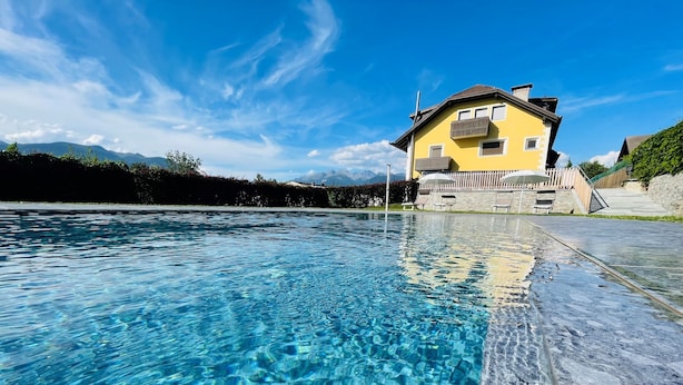 Ein klares Schwimmbecken mit einem Haus im Hintergrund.