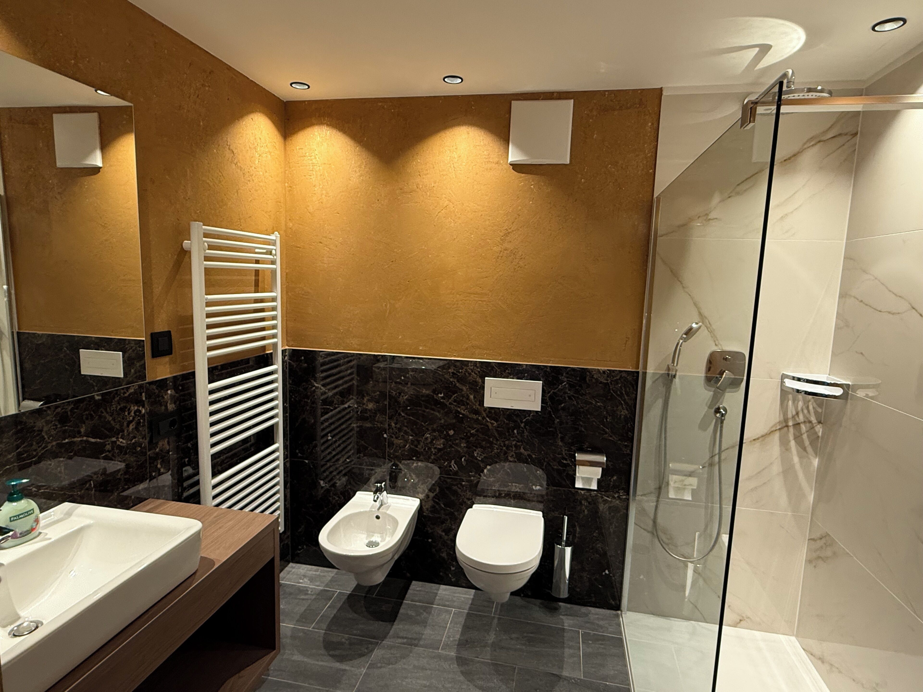 Ein modernes Badezimmer mit integriertem Bidet, Toilette und Dusche.
