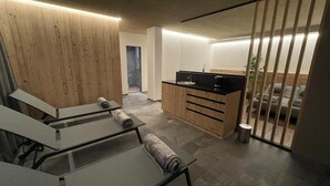Ein modernes, minimalistisches Badezimmer mit Duschkabine aus Glas, Holzschränken und einer kleinen Waschtisch-Ecke.