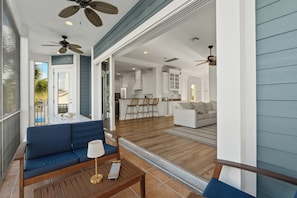 A modern living room with a blue sofa, a wooden coffee table, and a ceiling fan.