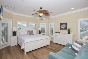 A bedroom with a large bed, a ceiling fan, a dresser, and a window with blinds. - 🌊Steps to Pool with Bay Views-Pet Friendly-4BR Blue View🌊 (Fort Myers Beach)