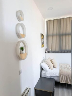 Escritorio, tabla de planchar con plancha, wifi y ropa de cama