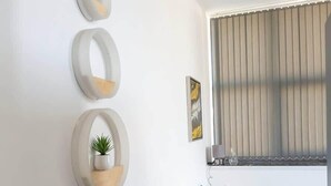 A modern bedroom with a bed, bedside table, and wall-mounted decor.