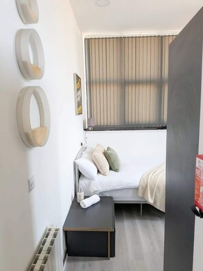 Escritorio, tabla de planchar con plancha, wifi y ropa de cama