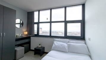 Desk, iron/ironing board, bed sheets