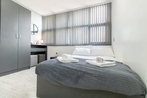 Desk, iron/ironing board, bed sheets