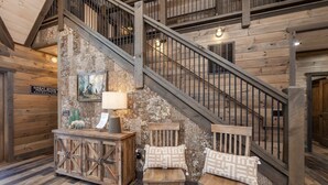 Ein rustikales Interieur mit einer Holztreppe, einer hölzernen Bank und einem Schrank mit einer Lampe.