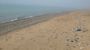 Een strand met een kiezelstrand en helder uitzicht op de zee.