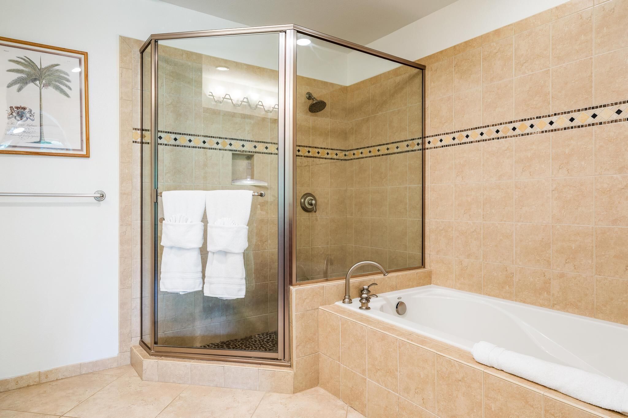 Une salle de bain moderne avec une douche à parois de verre, une baignoire et des murs recouverts de carreaux beiges.