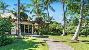 A resort with a covered outdoor area, palm trees, and a well-maintained lawn. - Mauna Lani Beach Club Pass included!  Palm Villas B4 (Waimea)