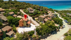 A coastal residential area with houses, a clear view of the sea, and a marked location. - Vacation home Luli by Interhome (Villasimius)