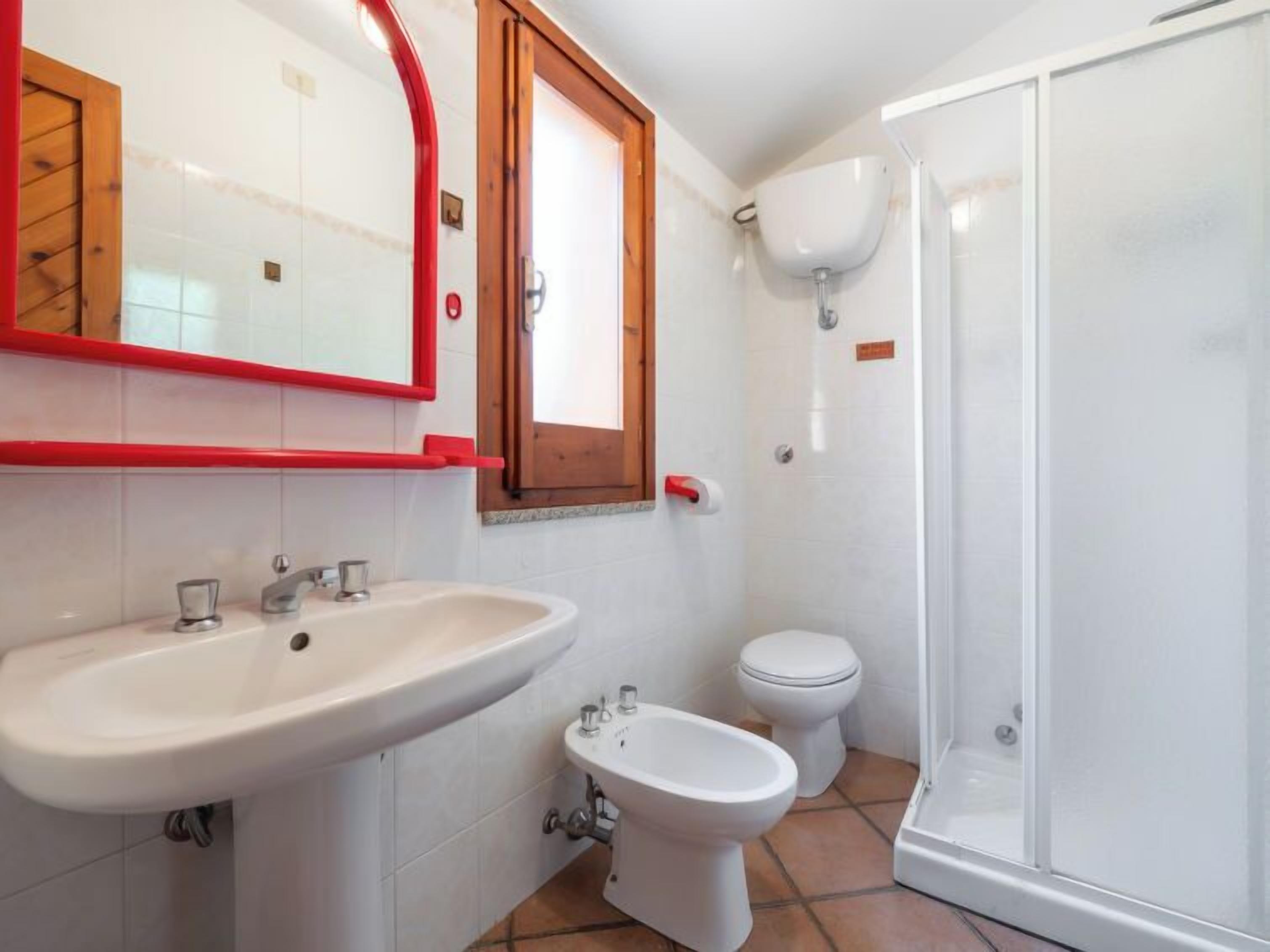 Une salle de bain équipée d’un lavabo, d’un bidet, de toilettes et d’une douche à parois de verre.