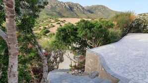 A stone pathway leading to a terrace with a view of a mountainous landscape. - Vacation home Luli by Interhome (Villasimius)