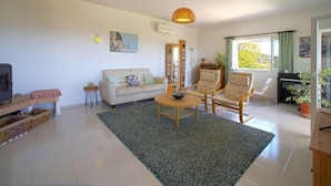 A living room with a sofa, two armchairs, a coffee table, a TV, and a fireplace. - Vacation home Vista by Interhome (São Bartolomeu de Messines)