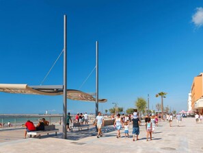 A promenade with a beach view, benches, and people walking. - Le Sunset/Cap Sud by Interhome (Cap d'Agde)