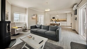 A modern living room with a grey sofa, a white coffee table, and a black fireplace. - Beautiful detached Villa, 10 minutes walk from Porto Do Mos beach (Lagos)