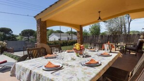 An outdoor patio with a covered dining area, tables set with plates, glasses, and a fruit bowl. - Ca La Lou by Interhome (Sils)