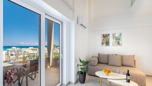 Un soggiorno moderno con un balcone, un divano, un tavolino e una pianta in vaso.