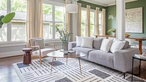 A living room with a grey sofa, a round coffee table, and a patterned rug.
