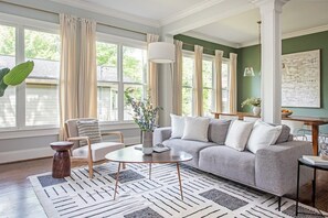 A living room with a grey sofa, a round coffee table, and a patterned rug.
