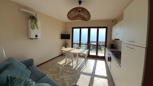 Un espace de vie compact comprenant une kitchenette, un coin repas et un canapé.