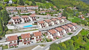 Un quartier résidentiel composé de plusieurs maisons à deux étages, d’une piscine et d’une route.