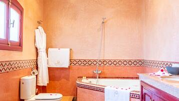 Une salle de bain équipée d’une baignoire, de toilettes, d’un lavabo et d’une douche.