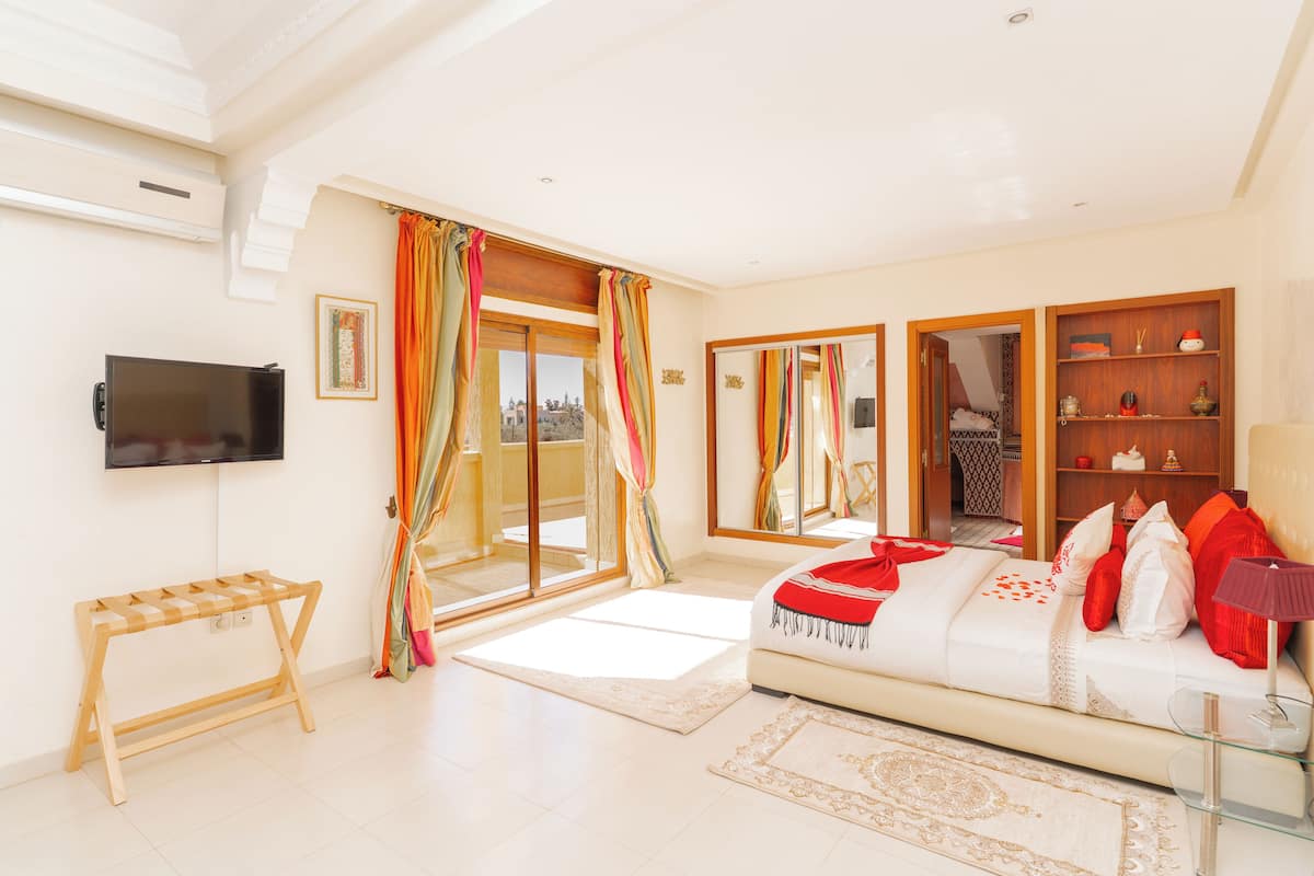 A spacious living room with a sofa, a TV, and a glass coffee table.